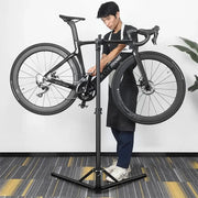 WEST BIKING Foldable Repair Stand holding a bike for drivetrain maintenance